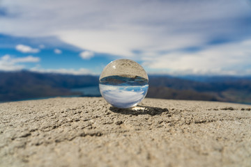 Fototapeta na wymiar lensball on top of Roys peak, crystal glas ball on top of Roys peak, glas ball on top of a mountain in New Zealand, great Roys peak in wanaka New Zealand