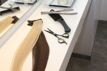 different extensions with comb and scissors in hair salon