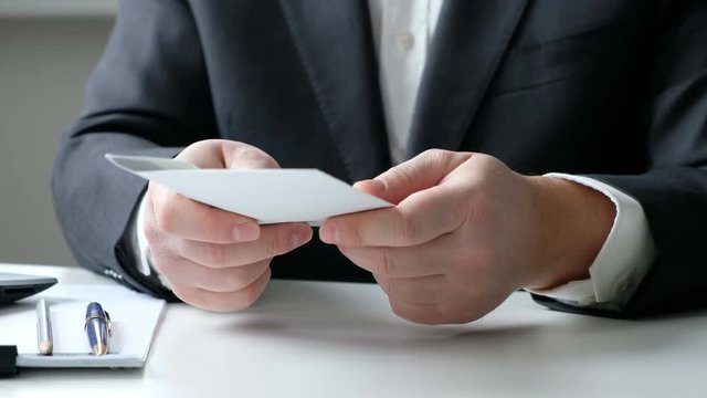 A man giving bribe money in a white envelope to another businessman in a corruption scam, close up