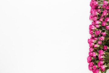 Flowers composition. Frame made of red rose on white wooden background. Flat lay, top view, copy space.