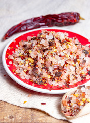 Gross sea salt mixed with dried red hot chili pepper, colorful seasoning close-up