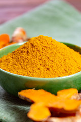 Fresh turmeric or curcuma root and dried powder, wildly used in Asia and India as spice, food ingredient and for medicinal purposes.