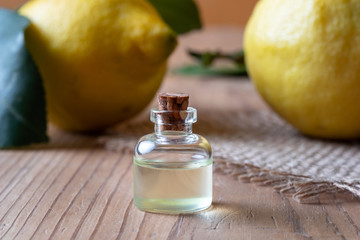 A bottle of lemon essential oil with fresh lemons