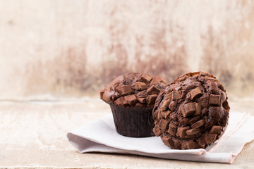 Homemade muffins with chocolate, vintage background.