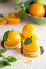 Mousse dessert with orange zest and mint in the shape of an orange fruit