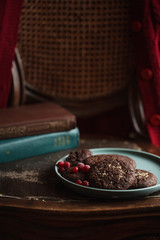Chocolate cookies with frozen cherries on the plate. Dark and Moody, Mystic Light food photo