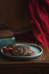 Chocolate cookies with frozen cherries on the plate. Dark and Moody, Mystic Light food photo