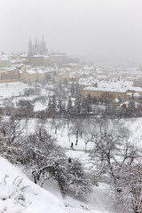 Snowy foggy Prague City with gothic Castle from Hill Petrin, Czech republic