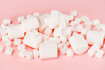 Various white marshmallows on the pink background