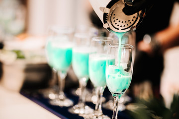 Barman creating professional cocktails. Details of alcoholic drinks and beverages at pub or bar. Blue curacao tropical cocktails