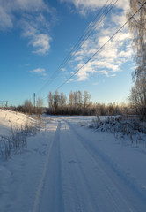 Car tracks on a deep snow. Beautiful winter day, sunlight and blue sky.