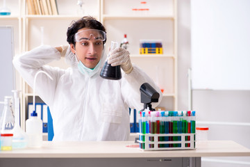 Young handsome chemist working in the lab