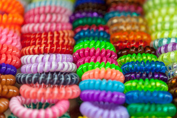 a lot of multi colored scrunchie for style hair. selective focus. colored background.