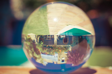 crystal ball reflecting dream house with pool on a sunny day