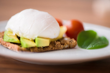 Healthy breakfast with wholemeal toast and benedict eggs with green salad and avocado