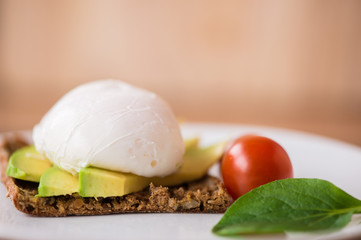 Healthy breakfast with wholemeal toast and benedict eggs with green salad and avocado