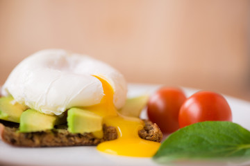 Healthy breakfast with wholemeal toast and benedict eggs with green salad and avocado