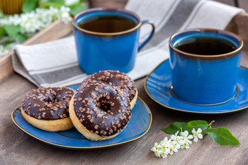 Chocolate donuts and cups of tea