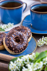 Chocolate donuts and cups of tea