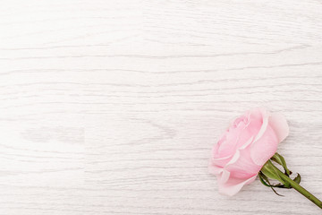 Frame made from pink, red, white roses on vintage white wooden background effect. Flat lay, top view.