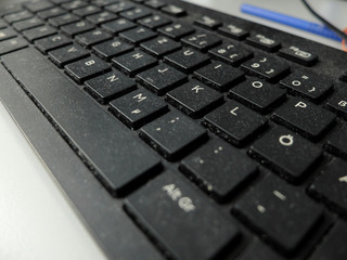 Closeup of the black dusty keyboard with German layout