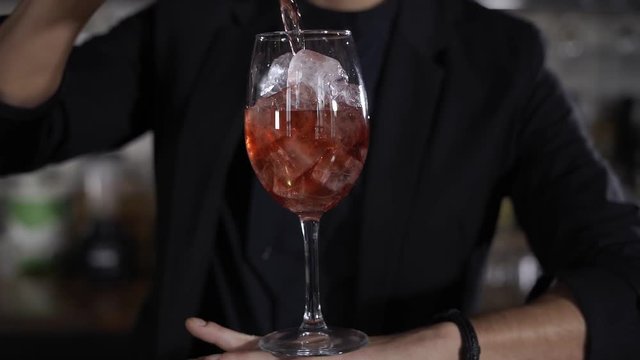 Wine pouring from the bottle into glass in a bar