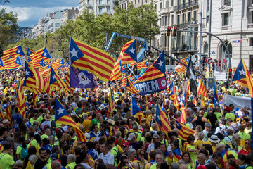 People wave 'Esteladas' (pro-independence Catalan flags) as they gather during a pro-independence...