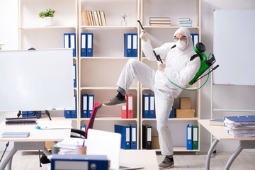 Professional contractor doing pest control at office