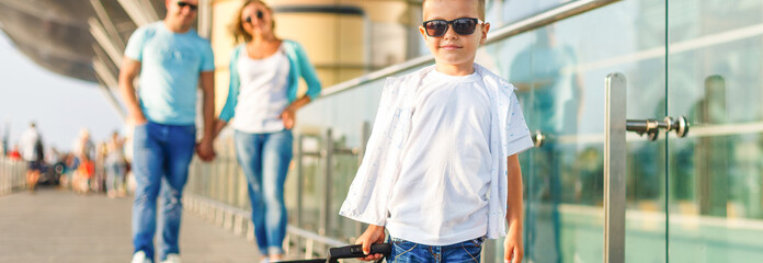 Cute little boy with suitcase at airport