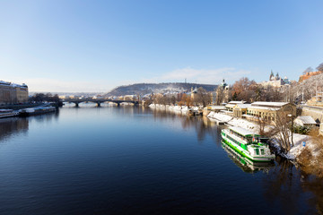 Fototapeta premium Snowy Prague Lesser Town with Prague Castle above River Vltava in the sunny Day, Czech republic