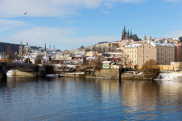 Obraz premium Snowy Prague Lesser Town with Prague Castle above River Vltava in the sunny Day, Czech republic