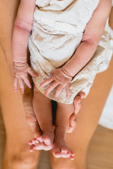 Small legs and feet of newborn baby on his bed.