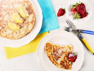Shrove Pancake Tuesday pancakes with lemons and strawberries with lens flare.