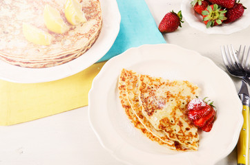 Shrove Pancake Tuesday pancakes with lemons and strawberries with lens flare.