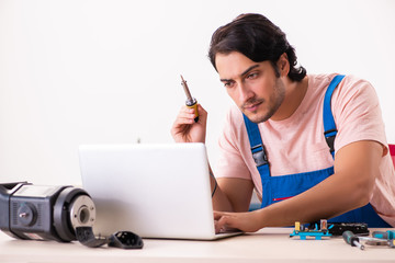 Young male contractor repairing computer