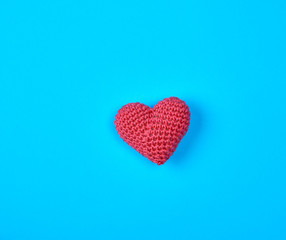 small red knitted heart on a blue background