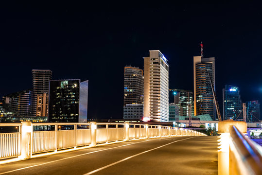 Crossing the bridge against the background of lighting skyscrapers