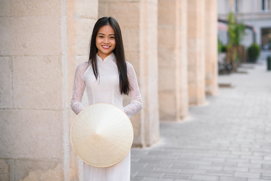 Close up portrait of pretty asian girl dressed in Ao Dai dress with vietnamese conical hat.
