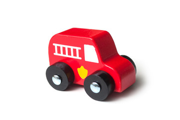 Naklejka premium closeup of red miniature wooden truck on white background - concept fire rescue