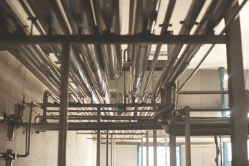 Equipment and piping inside of industrial plant. Factory. Various mechanisms and metal pipes. Toned image.