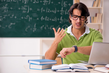 Handsome student in front of chalkboard with formulas