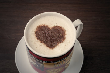 Coffee cup with heart shape cinnamon on wood background. Valentine's concept