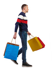 Side view of going man with shopping bags.