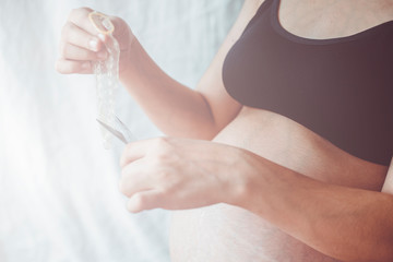 Pregnant woman cutting a condom
