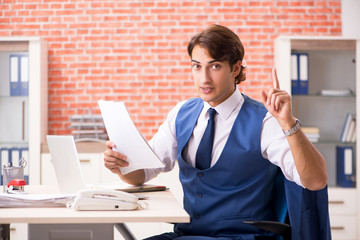 Young handsome employee working in the office