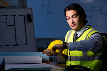 Young construction architect working on project at night