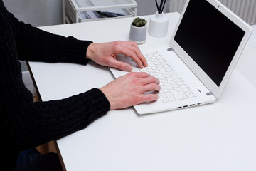 Man using a laptop to send emails from office