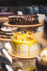 Different types Cake tray in showcase. Glass display at store bakery pastry shop. Showcase with sweets cakes for sale in cake shop. cake and people in cafe concept.
