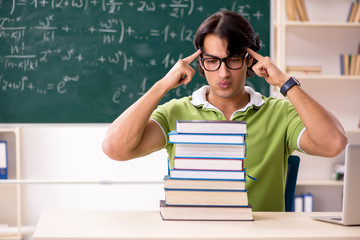 Handsome student in front of chalkboard with formulas