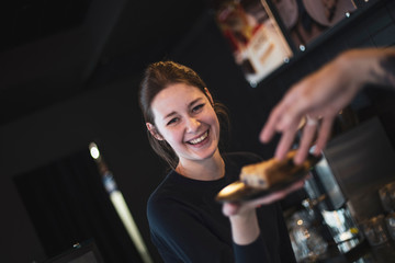 waiters are fun at work, the hand of a boy who stretches to a plate with a cake kept by a smiling...